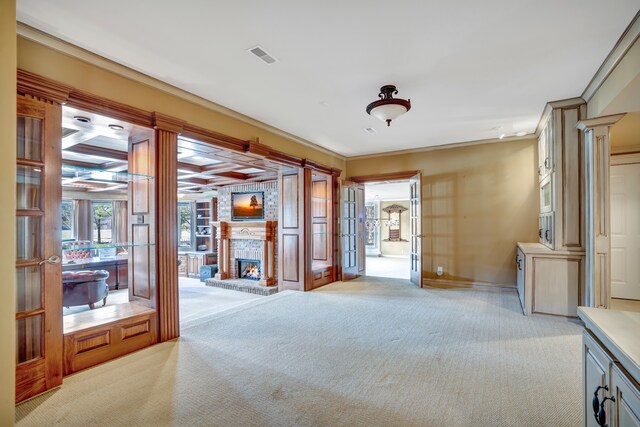 miscellaneous room featuring a fireplace, light colored carpet, visible vents, ornamental molding, and ornate columns