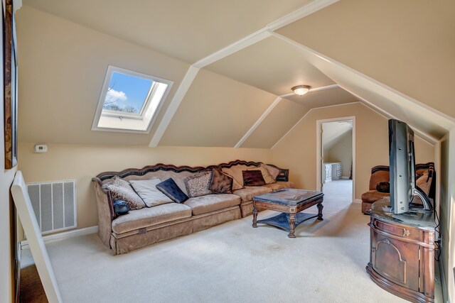 carpeted living area with vaulted ceiling with skylight and visible vents