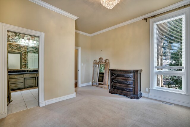 unfurnished living room with a notable chandelier, light colored carpet, visible vents, ornamental molding, and baseboards