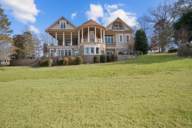 view of front of house with stone siding, stairs, and a front lawn