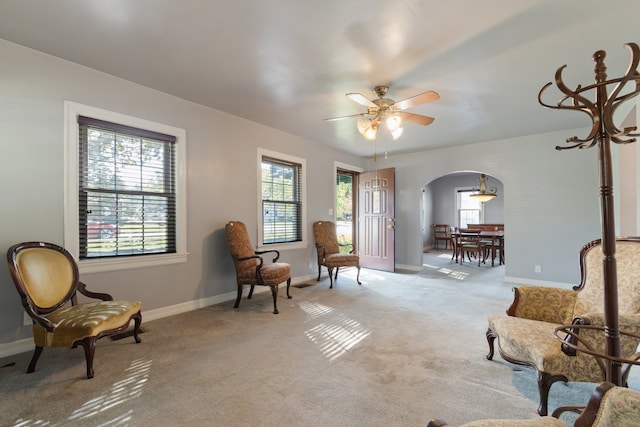 sitting room with ceiling fan and light colored carpet