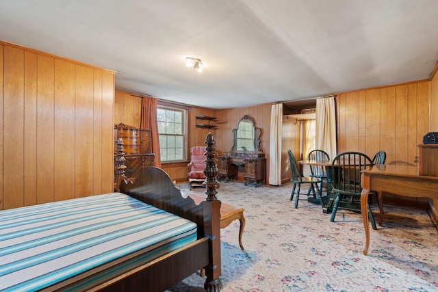 carpeted bedroom featuring wood walls