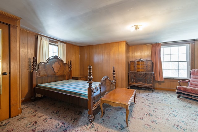 bedroom featuring wooden walls and multiple windows