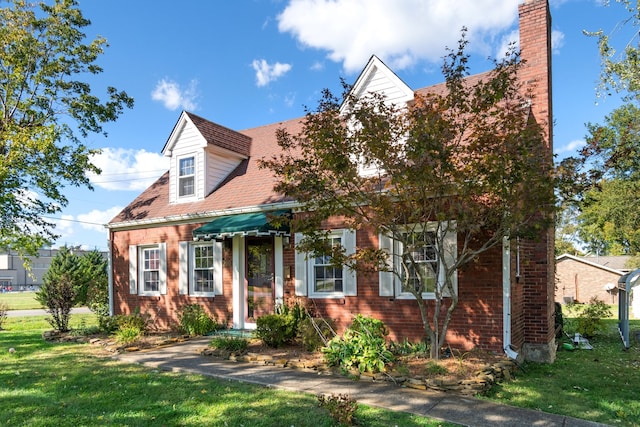 cape cod-style house featuring a front yard