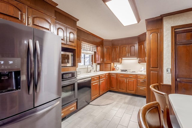 kitchen with appliances with stainless steel finishes, sink, and crown molding