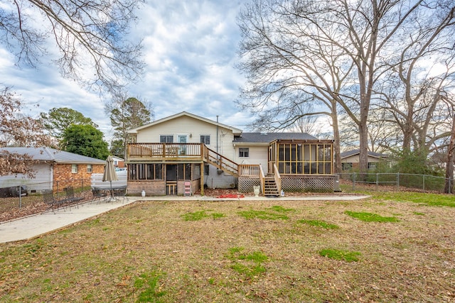 back of property with a wooden deck, a lawn, and a sunroom