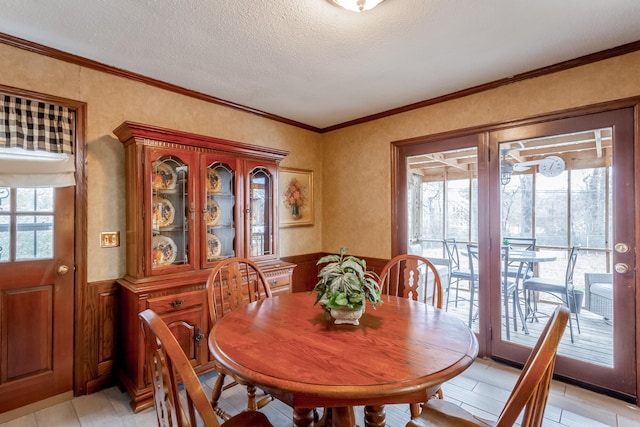 tiled dining area with ornamental molding and a textured ceiling