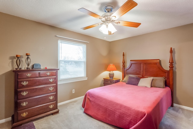 carpeted bedroom featuring ceiling fan and a textured ceiling