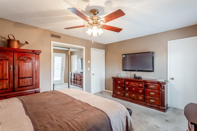 carpeted bedroom featuring ceiling fan and a closet