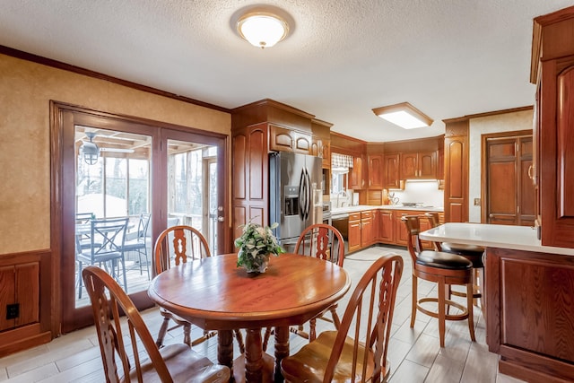 dining room with ornamental molding and a textured ceiling