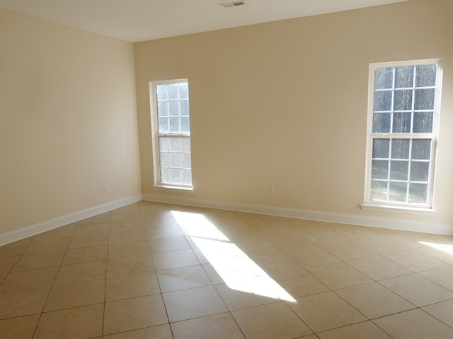 tiled empty room with a healthy amount of sunlight