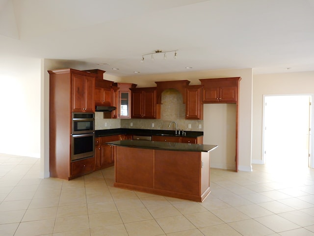 kitchen with light tile floors, a kitchen island, stainless steel double oven, and sink