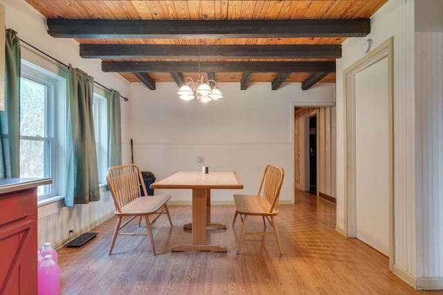 dining area with a wealth of natural light, beamed ceiling, and a chandelier