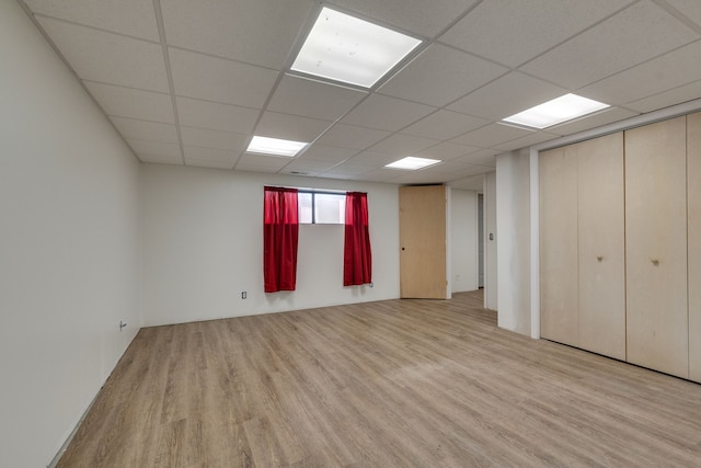 interior space featuring a paneled ceiling and light hardwood / wood-style floors