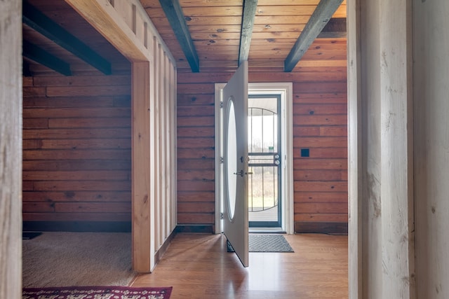 foyer entrance with dark hardwood / wood-style floors, wood ceiling, wood walls, and beamed ceiling