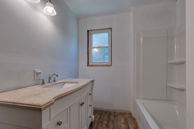 bathroom with bathing tub / shower combination, vanity, and hardwood / wood-style flooring