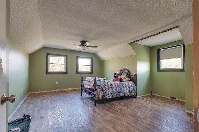 bedroom featuring a textured ceiling, ceiling fan, dark wood-type flooring, and lofted ceiling