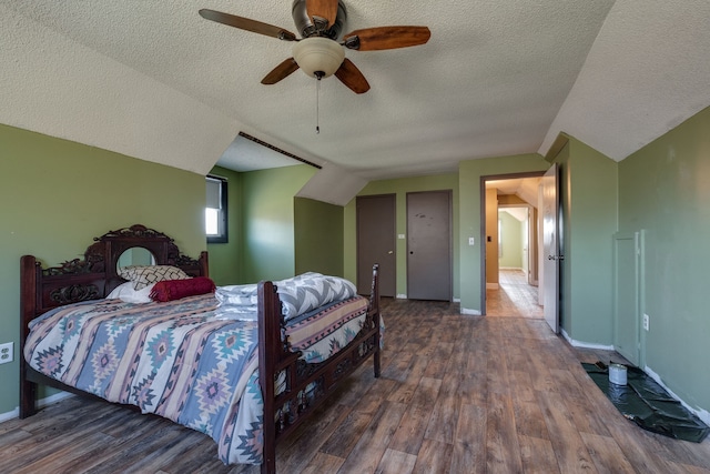 bedroom featuring ceiling fan, lofted ceiling, dark hardwood / wood-style flooring, and a textured ceiling