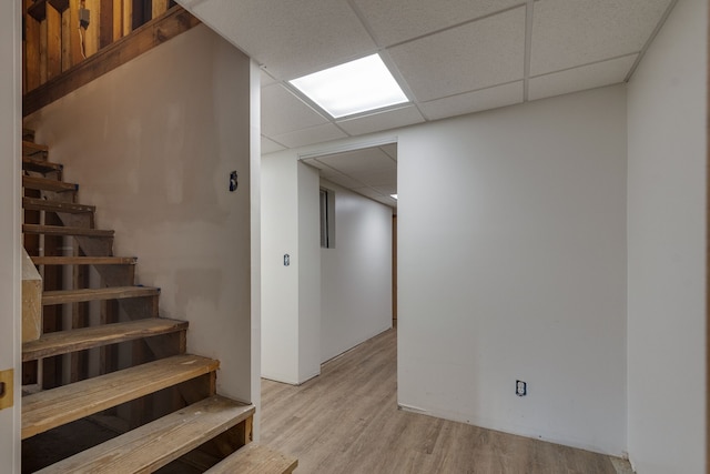 interior space featuring a drop ceiling and light hardwood / wood-style floors