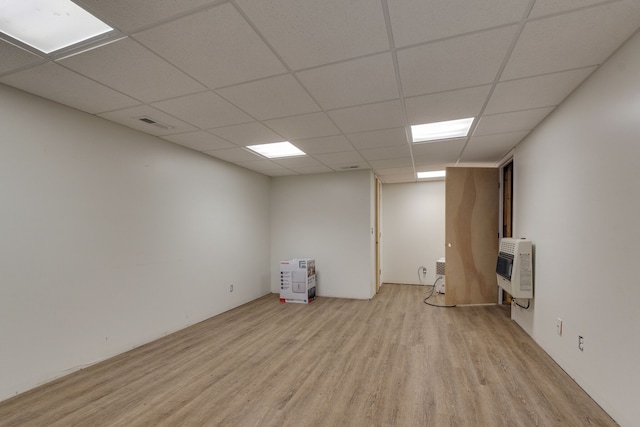 basement featuring light hardwood / wood-style flooring and a paneled ceiling