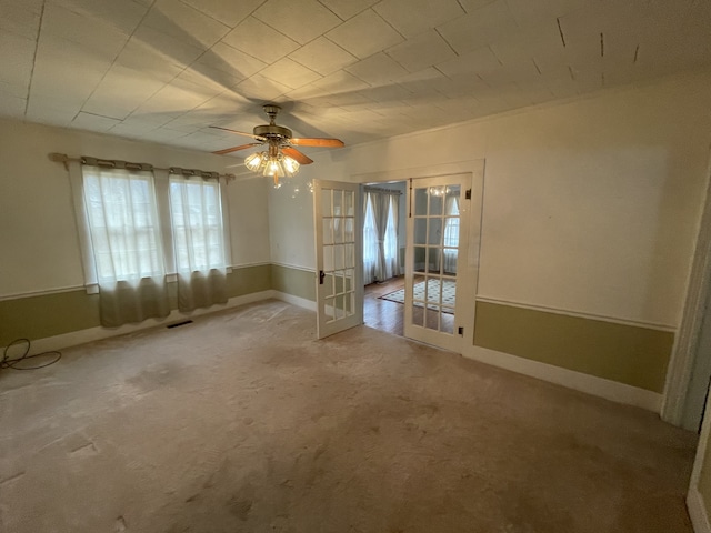 spare room featuring ceiling fan, light carpet, and french doors