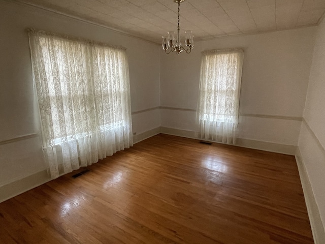 empty room featuring light hardwood / wood-style floors and a chandelier