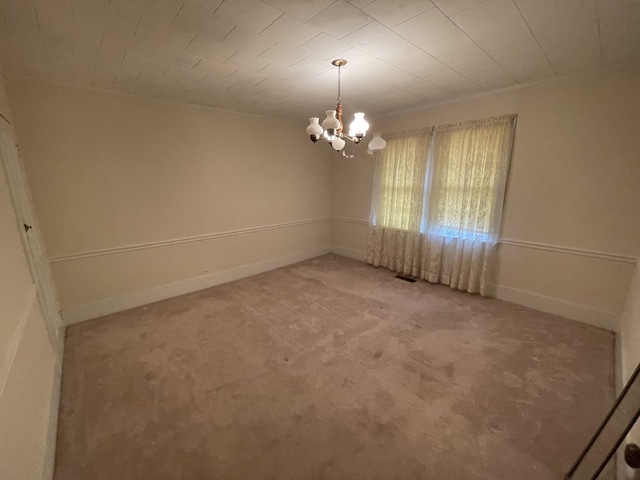 spare room with light carpet and an inviting chandelier