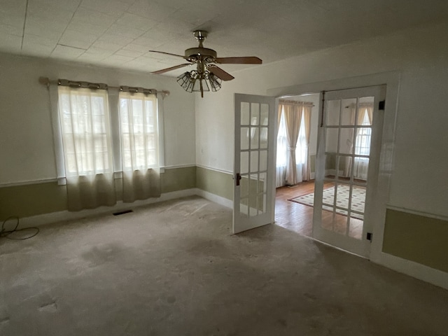 carpeted empty room with ceiling fan and french doors