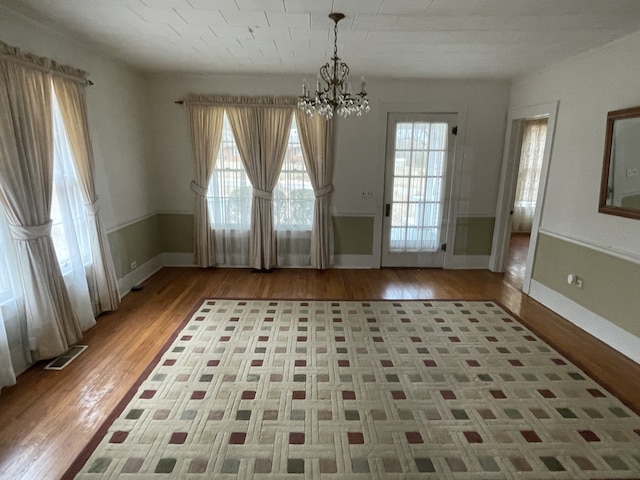 interior space with a notable chandelier and hardwood / wood-style flooring