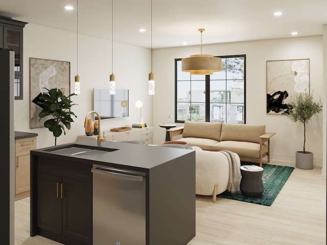 kitchen featuring decorative light fixtures, dishwasher, a center island with sink, light wood-type flooring, and sink