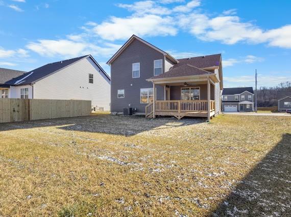 rear view of property featuring a lawn and central AC