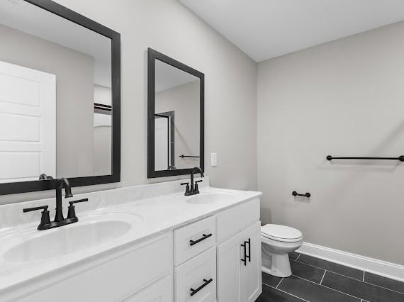 bathroom with toilet, tile patterned flooring, and vanity