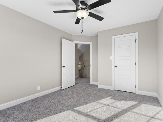 unfurnished bedroom with a closet, ceiling fan, and light carpet