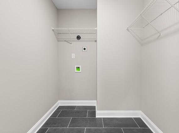 laundry room featuring dark tile patterned flooring and hookup for an electric dryer