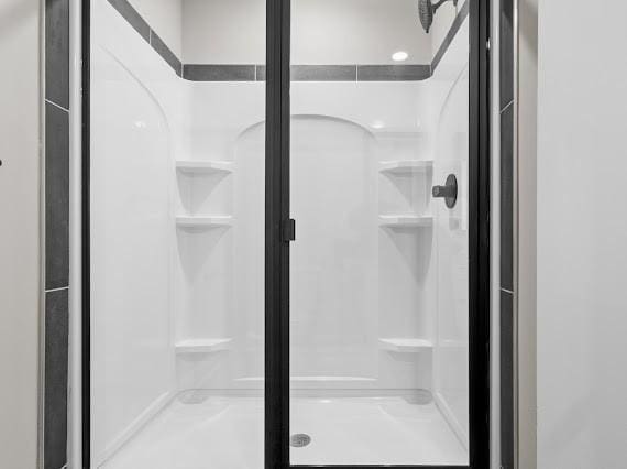 bathroom featuring a shower with shower door