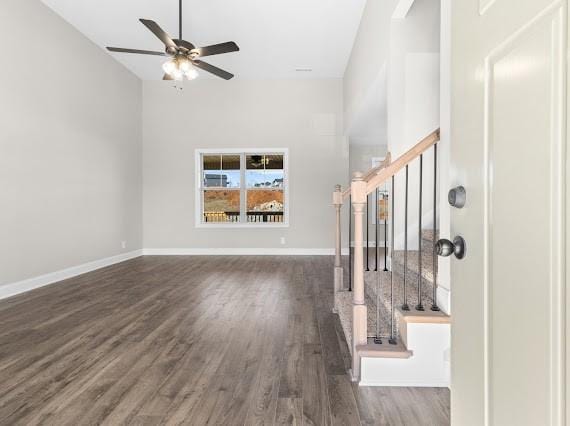 unfurnished living room with ceiling fan, a high ceiling, and dark hardwood / wood-style floors