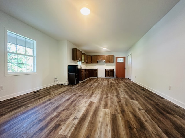 unfurnished living room with dark wood-type flooring and sink