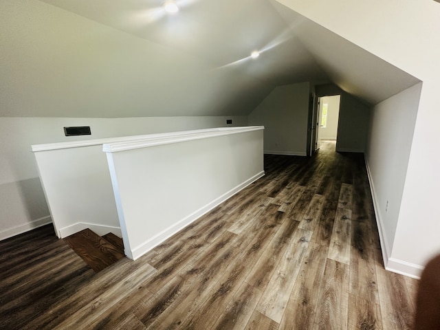 additional living space with vaulted ceiling and dark hardwood / wood-style floors