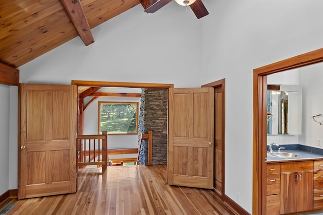 interior space with beam ceiling, wooden ceiling, ceiling fan, light wood-type flooring, and sink