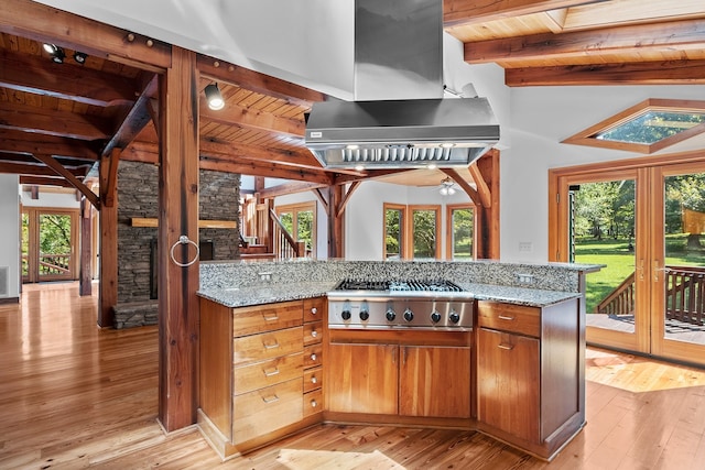 kitchen with light stone counters, plenty of natural light, fume extractor, light wood-type flooring, and wood ceiling