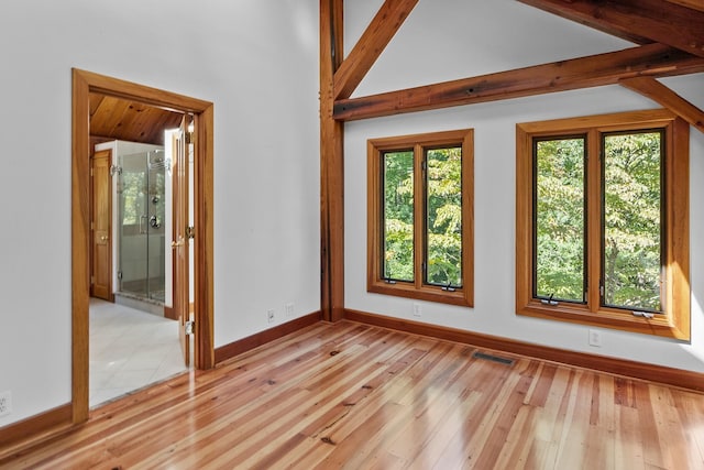 unfurnished room featuring light hardwood / wood-style floors and vaulted ceiling