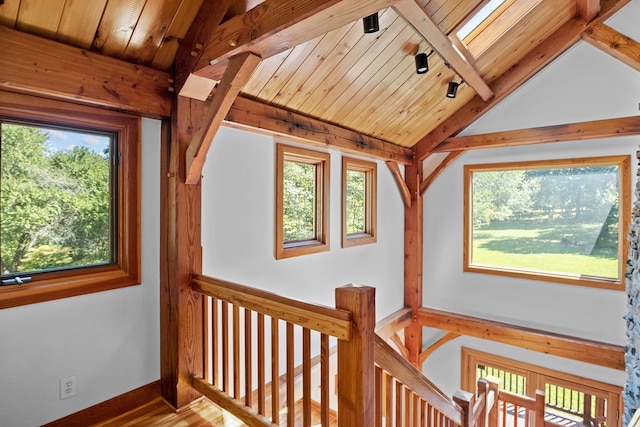 corridor with lofted ceiling with skylight, wooden ceiling, and hardwood / wood-style flooring