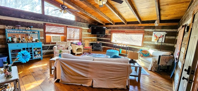 interior space with ceiling fan, a wood stove, light hardwood / wood-style flooring, lofted ceiling with beams, and wooden ceiling