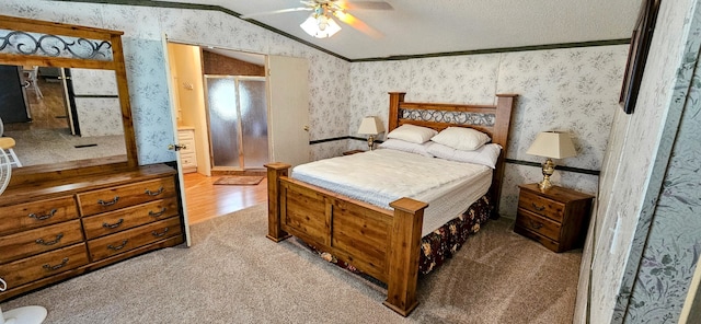 carpeted bedroom with lofted ceiling, ornamental molding, ceiling fan, and a textured ceiling