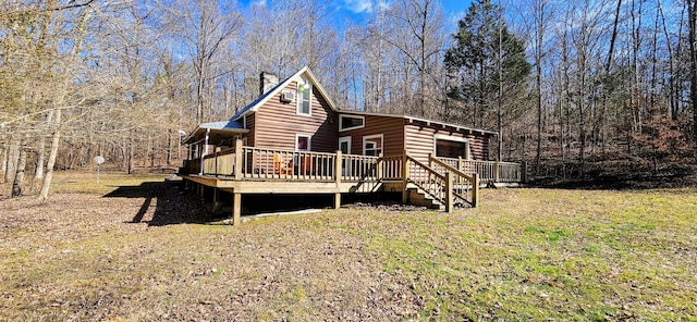 back of house featuring a wooden deck and a lawn