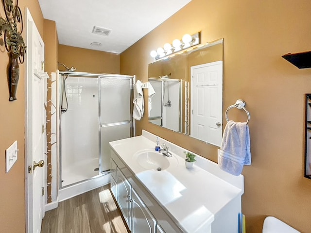 bathroom featuring vanity, hardwood / wood-style flooring, and an enclosed shower