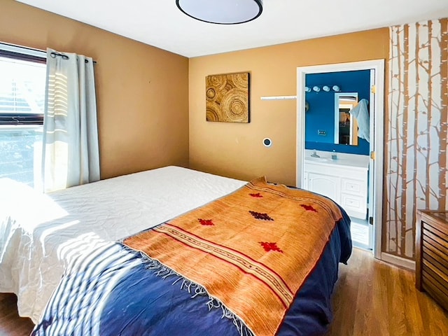 bedroom with ensuite bath and dark hardwood / wood-style flooring