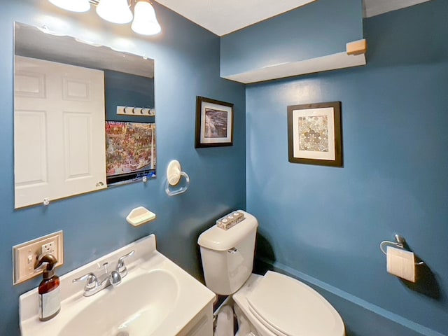 bathroom with toilet and vanity with extensive cabinet space