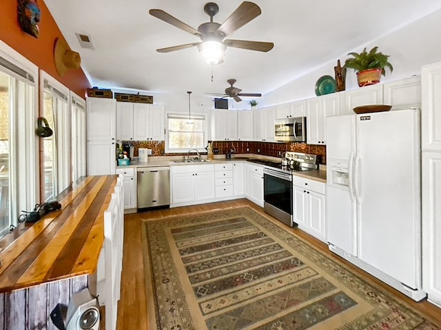 kitchen featuring white cabinets, tasteful backsplash, stainless steel appliances, and ceiling fan