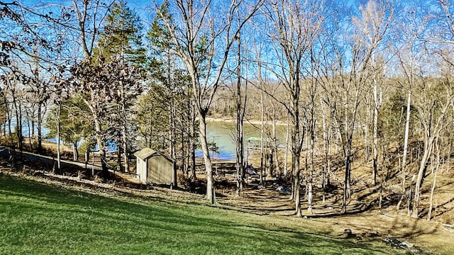 view of dock with a water view and a lawn